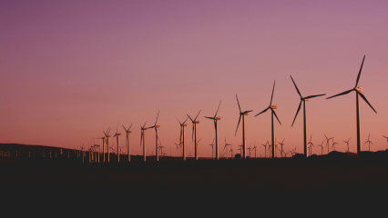 Row of wind turbines at sunset